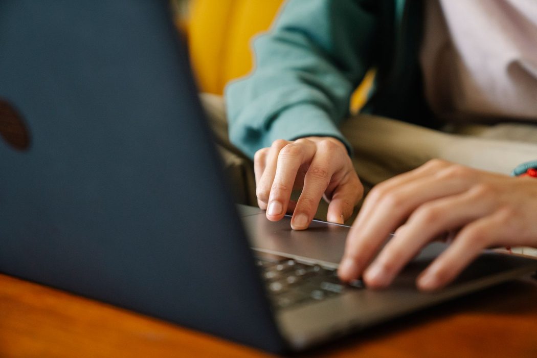 Person typing on a laptop keyboard at a desk